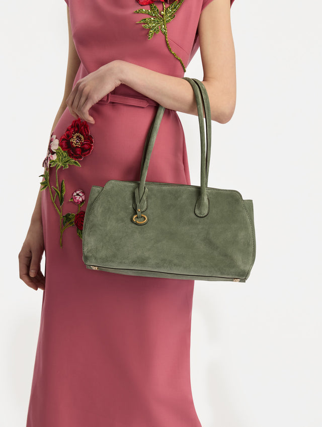 The Aster in sage has decisive lines and gently curved sides with the contours of the Oscar 'O.' Elongated top handles with gold hardware and an emblem-stamped tag. 