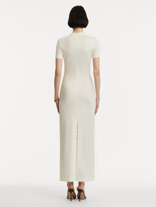 Full body back view of model wearing a short-sleeve jersey dress with a ivory base and concealed zipper. 