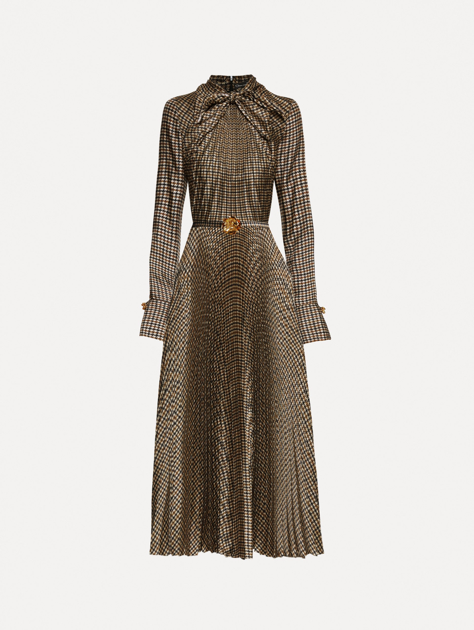 Multiple brown colored dress with a long sleeves and a neck tie. Dress also features pleating and a matching self-belt with a gold peony at the center. 