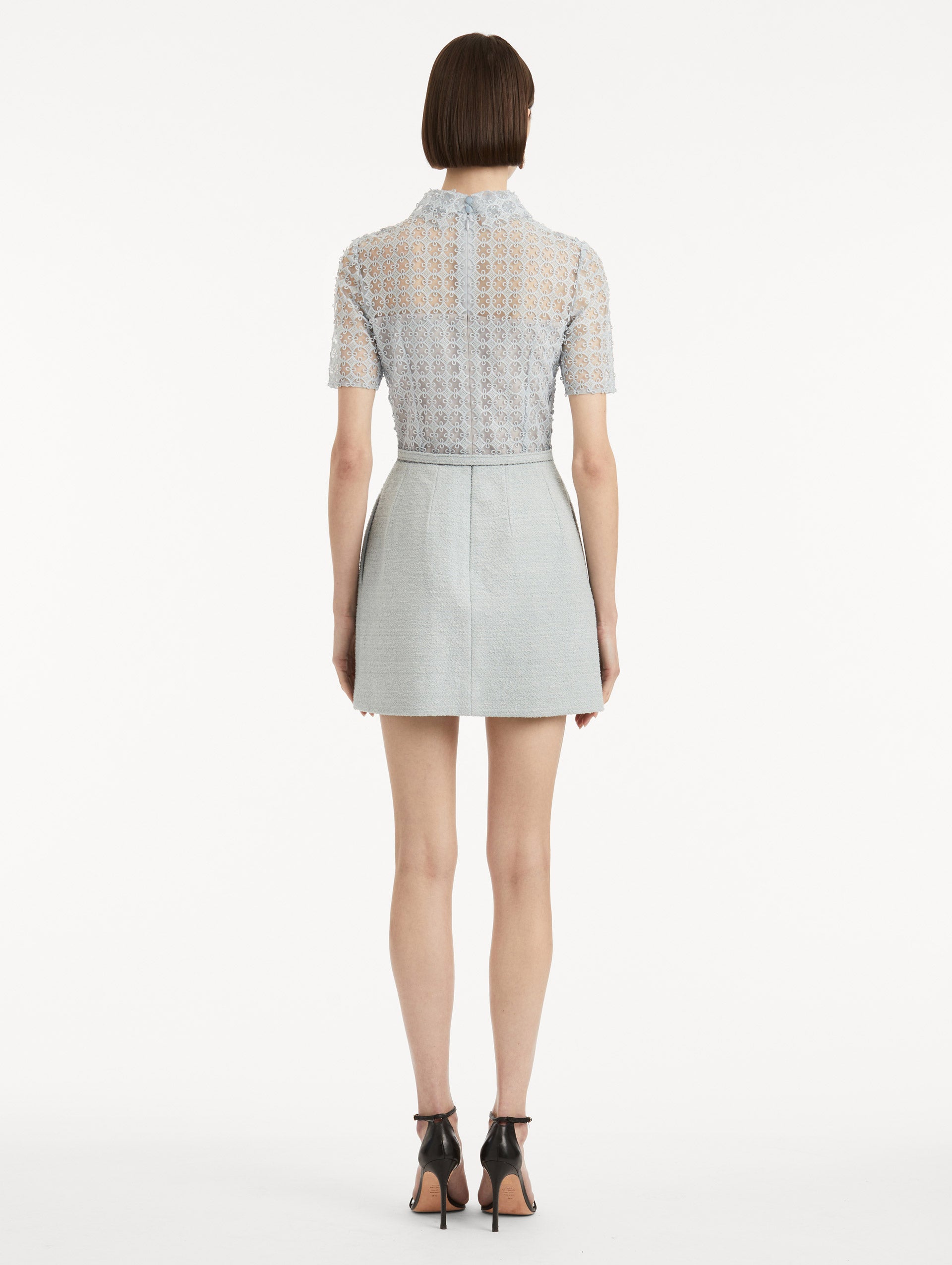 Back view of model wearing blue quartz tweed dress with lace top, short sleeves, collar, and matching tweed belt. 