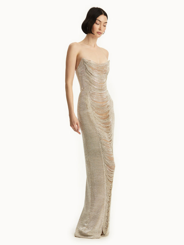 The model is wearing a strapless chain gown. Side view