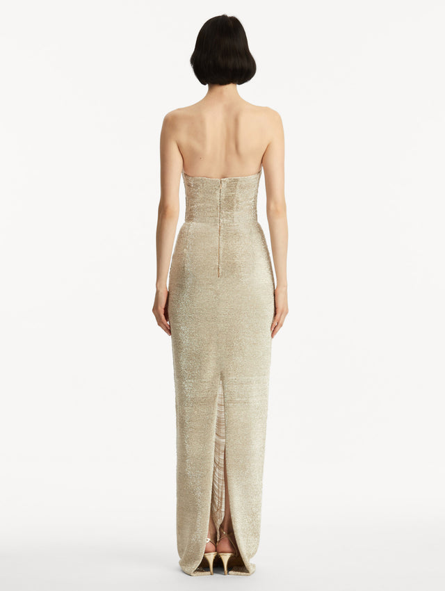 The model is wearing a strapless chain gown. Back view