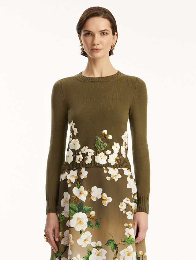 The model is wearing a Khaki pullover with white cherry blossoms embroidered in the bottom, over a matching dress. Front view