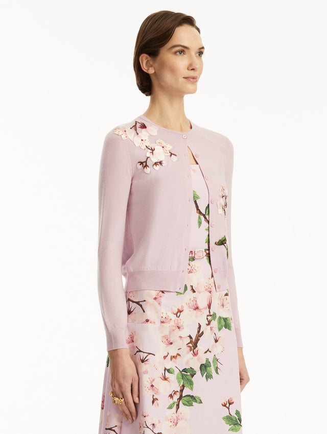 Model wearing lily cardigan with cherry blossom embroidery, paired with a cherry blossom dress. Side view