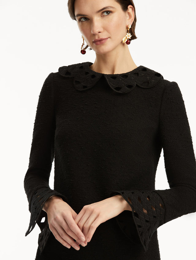 Model wearing black tweed long sleeve mini dress with threadwork cutouts at the scalloped collar and cuffs. Zoom view