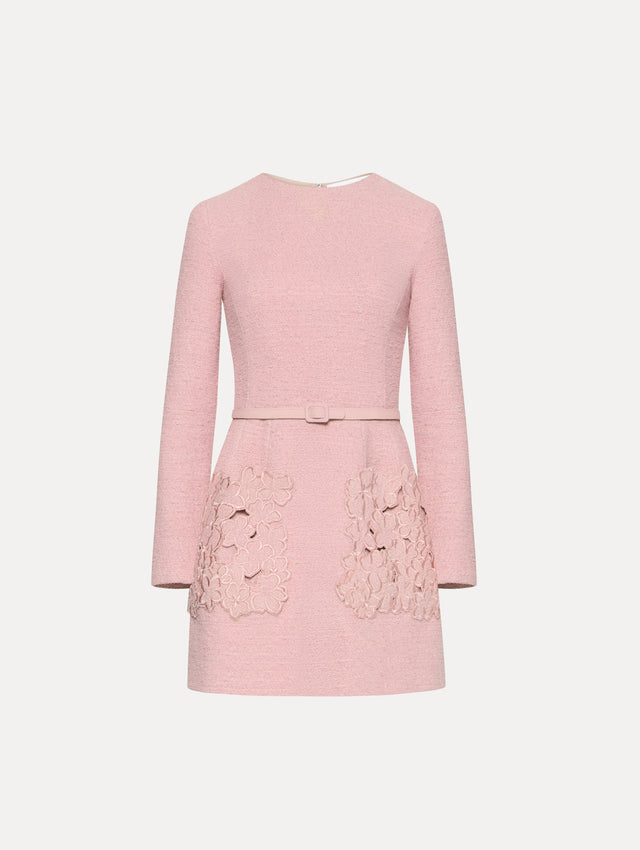 Long sleeve mini tweed dress in light pink, with a matching belt and lace pocket's. Front view
