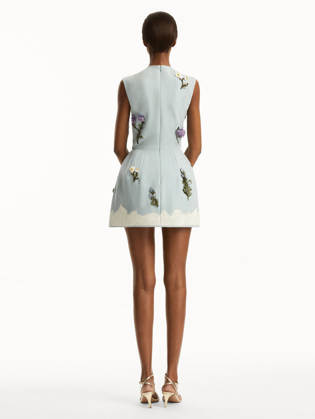 Sleeveless mini cocktail dress in light blue with embroidered crystal flowers and artichokes. Back view