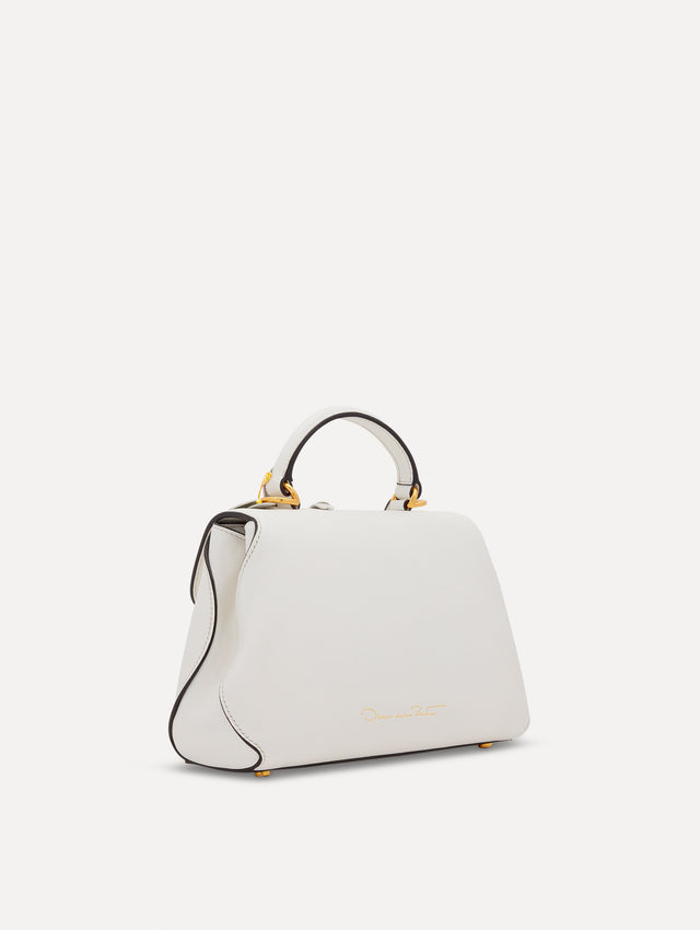 The Mini Poppy handbag in ivory with three-dimensional flowers attached. This bag comes with the Oscar O logo around the top handle, and a detachable shoulder strap. Side View.