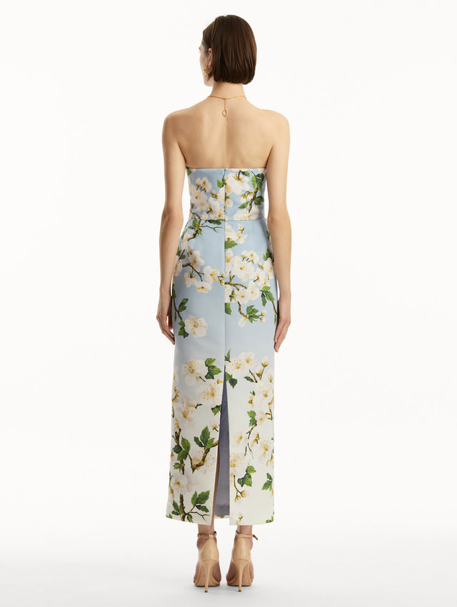 Model wearing blue to white ombre strapless gown with white cherry blossom print. Back view