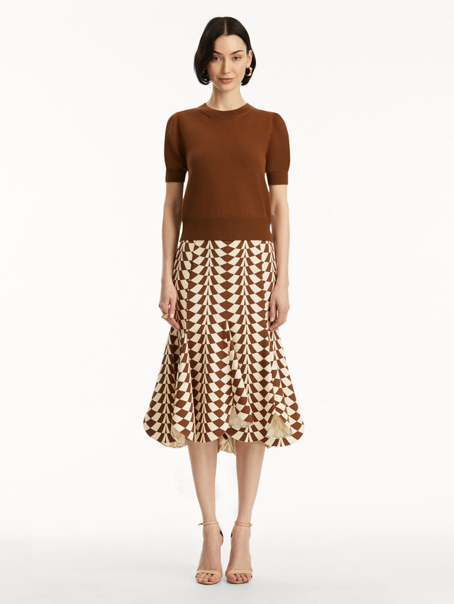Short sleeve brown wool pullover, paired with geometric print skirt. Front view