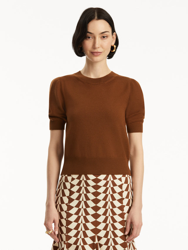 Short sleeve brown wool pullover, paired with geometric print skirt. Front view