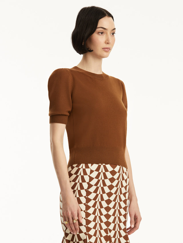 Short sleeve brown wool pullover, paired with geometric print skirt. Side view