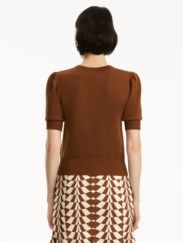 Short sleeve brown wool pullover, paired with geometric print skirt. Back view