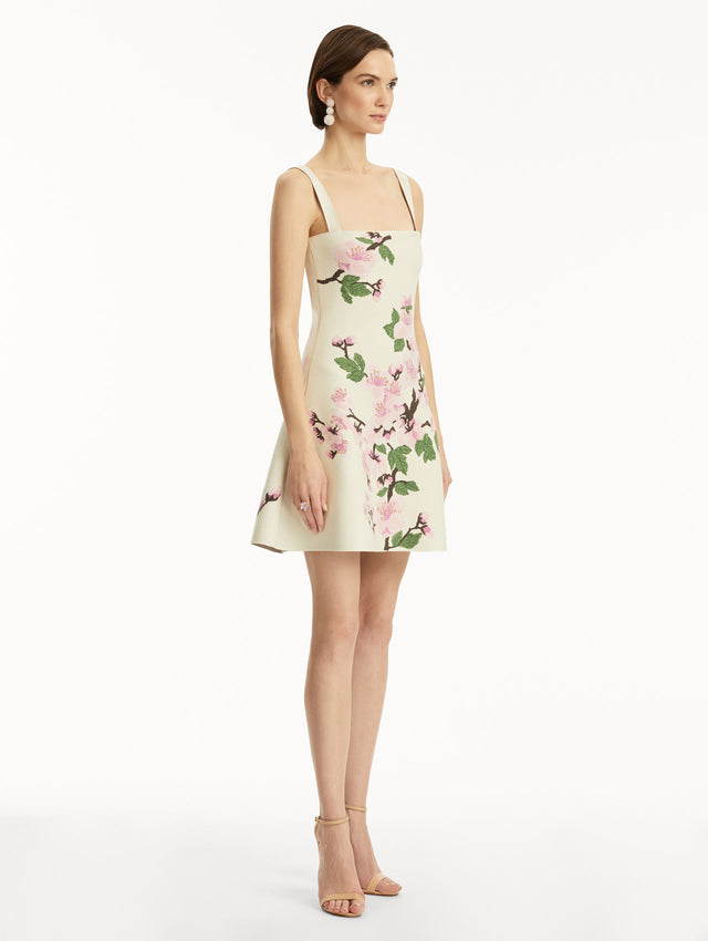 White knit mini jacquard sleeveless dress with pink cherry blossom print. Side view.