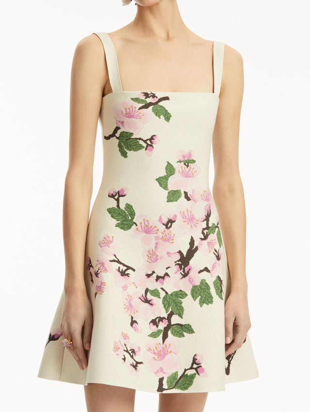 White knit mini jacquard sleeveless dress with pink cherry blossom print. Zoom view.
