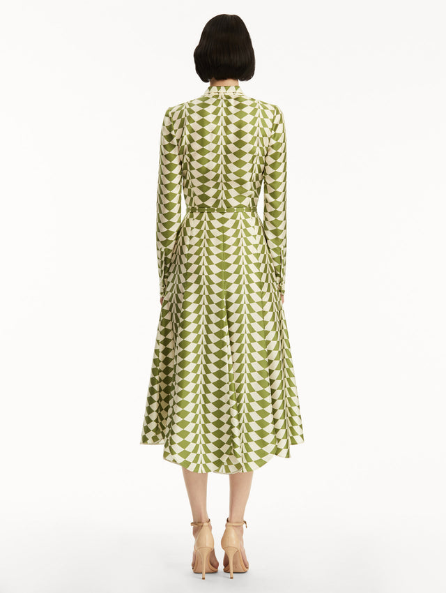 Long sleeve green and white geometric print silk midi dress with tie detail around the neck. Back view
