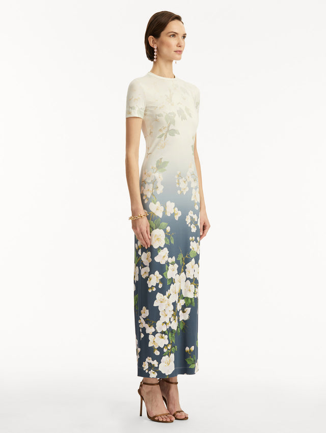 Model wearing ombre white to blue short sleeve long dress with white cherry blossom print. Side View