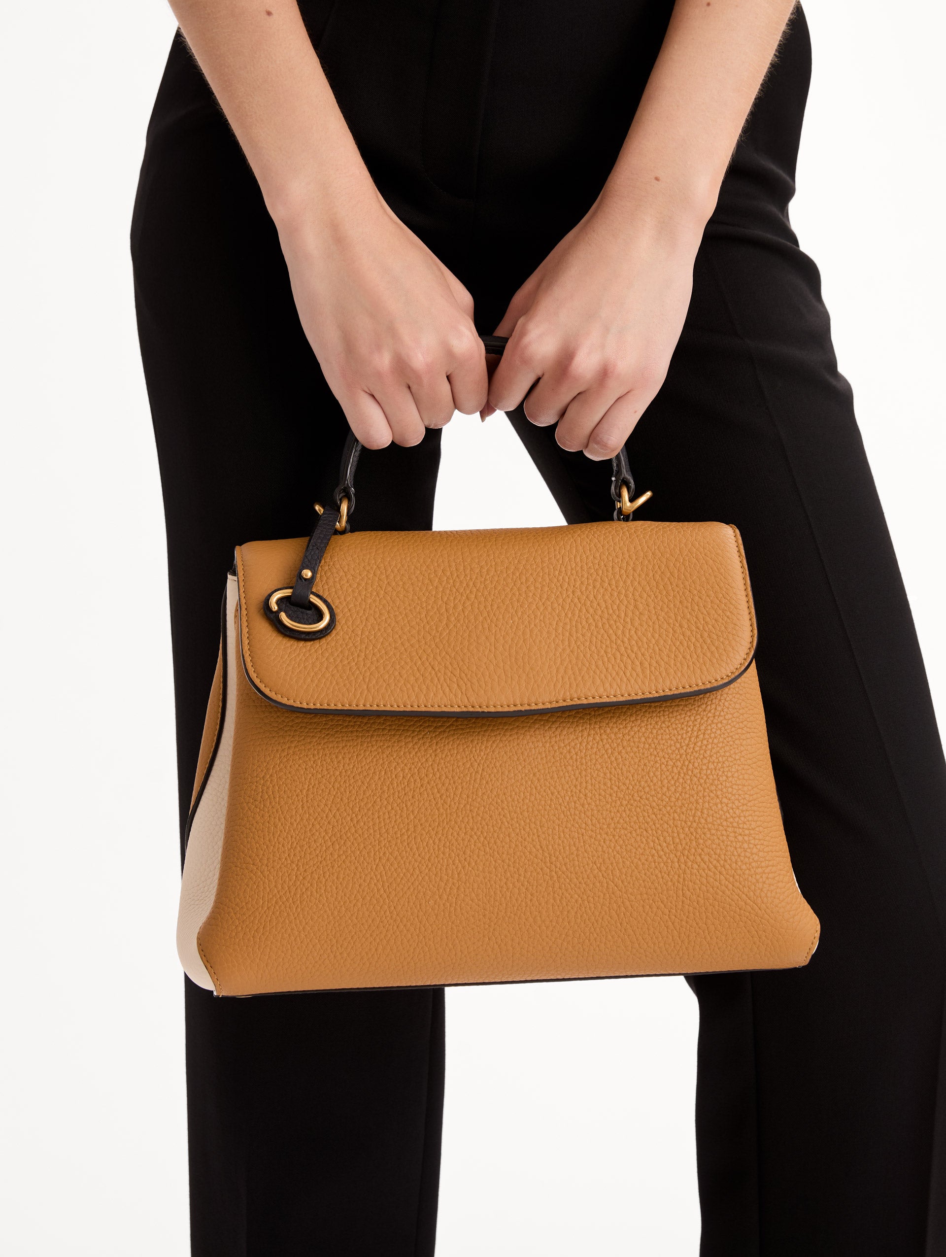 The Poppy Handbag in Honey with Black Top Handle and removeable shoulder strap. Adorned with Oscar de la Renta's signature O at the ornamental bag tag. Front View.