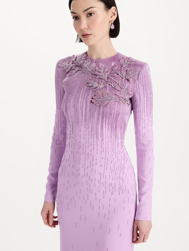 The model is wearing the intarsia leaves cutout embroidered gown with long sleeves in the color verbena. Zoom view. 