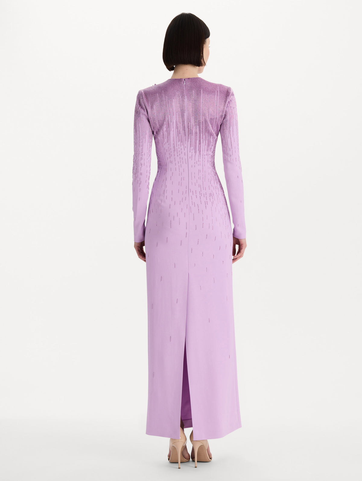 The model is wearing the intarsia leaves cutout embroidered gown with long sleeves in the color verbena. Back view. 