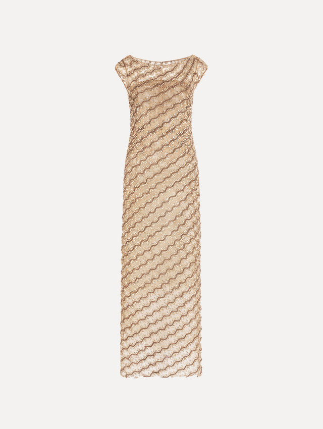 The model is wearing the beaded wave embroidered sleeveless cocktail dress in the color amber.