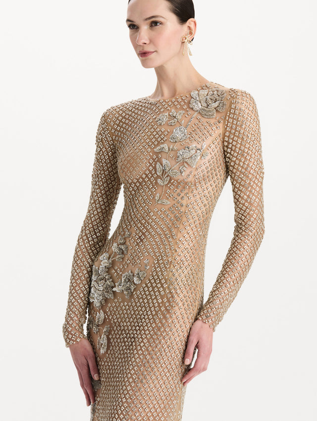 The model is wearing the crystal grid floral embroidered gown with long sleeves in the color silver. Zoom view. 