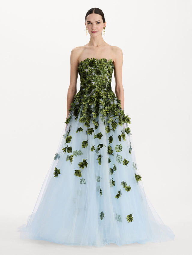 The model is wearing the maple leaf appliqué gown with a strapless silhouette in the color sky blue. Front view.