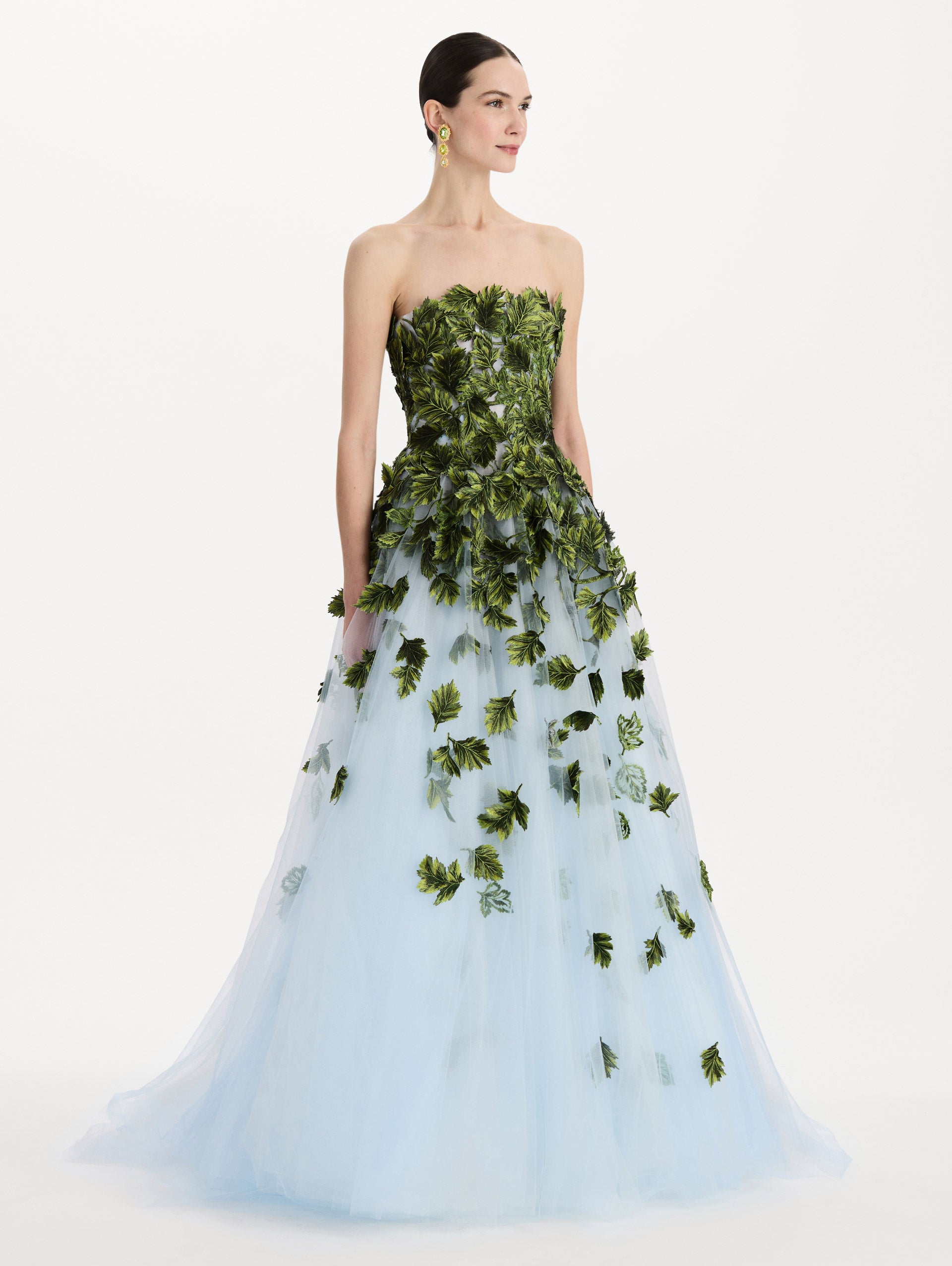 The model is wearing the maple leaf appliqué gown with a strapless silhouette in the color sky blue. Side view.