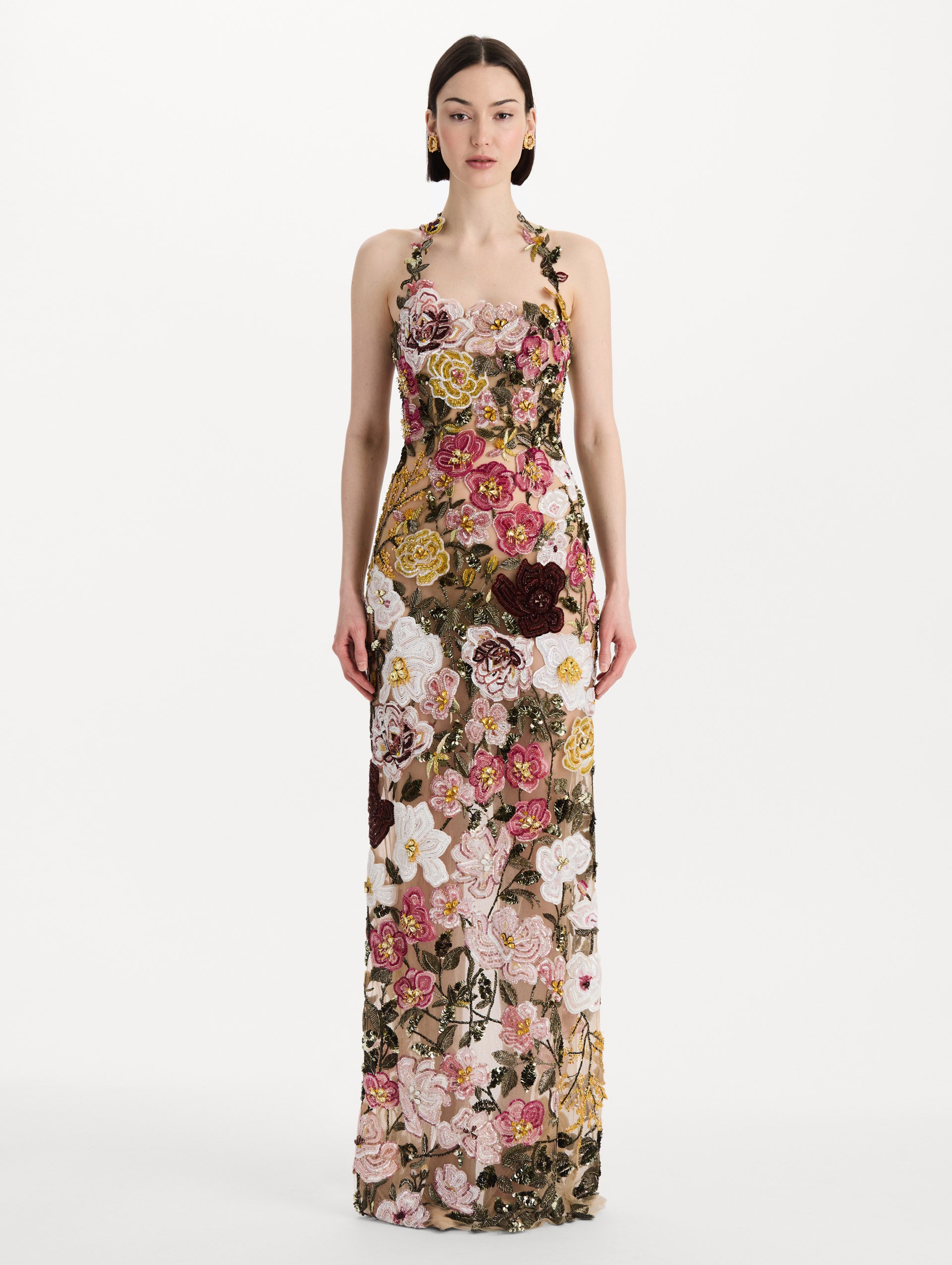 The model is wearing the beaded mixed botanical embroidered gown in multi-color with a halter neckline and floral detailing. Front view.