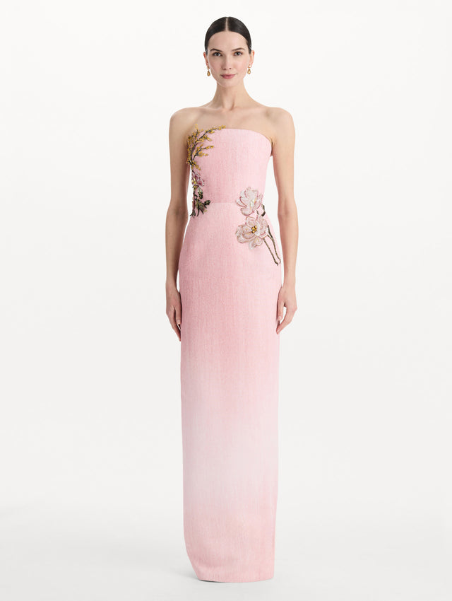 The model is wearing the beaded mixed botanical embroidered column gown with floral detailing and a strapless silhouette in the color blush. Front view.