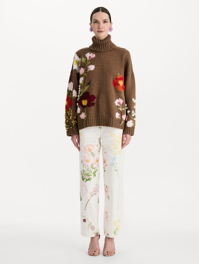 The model is wearing the mixed botanical embroidered oversized pullover with a floral intarsia pattern in the color brown. Front view. 