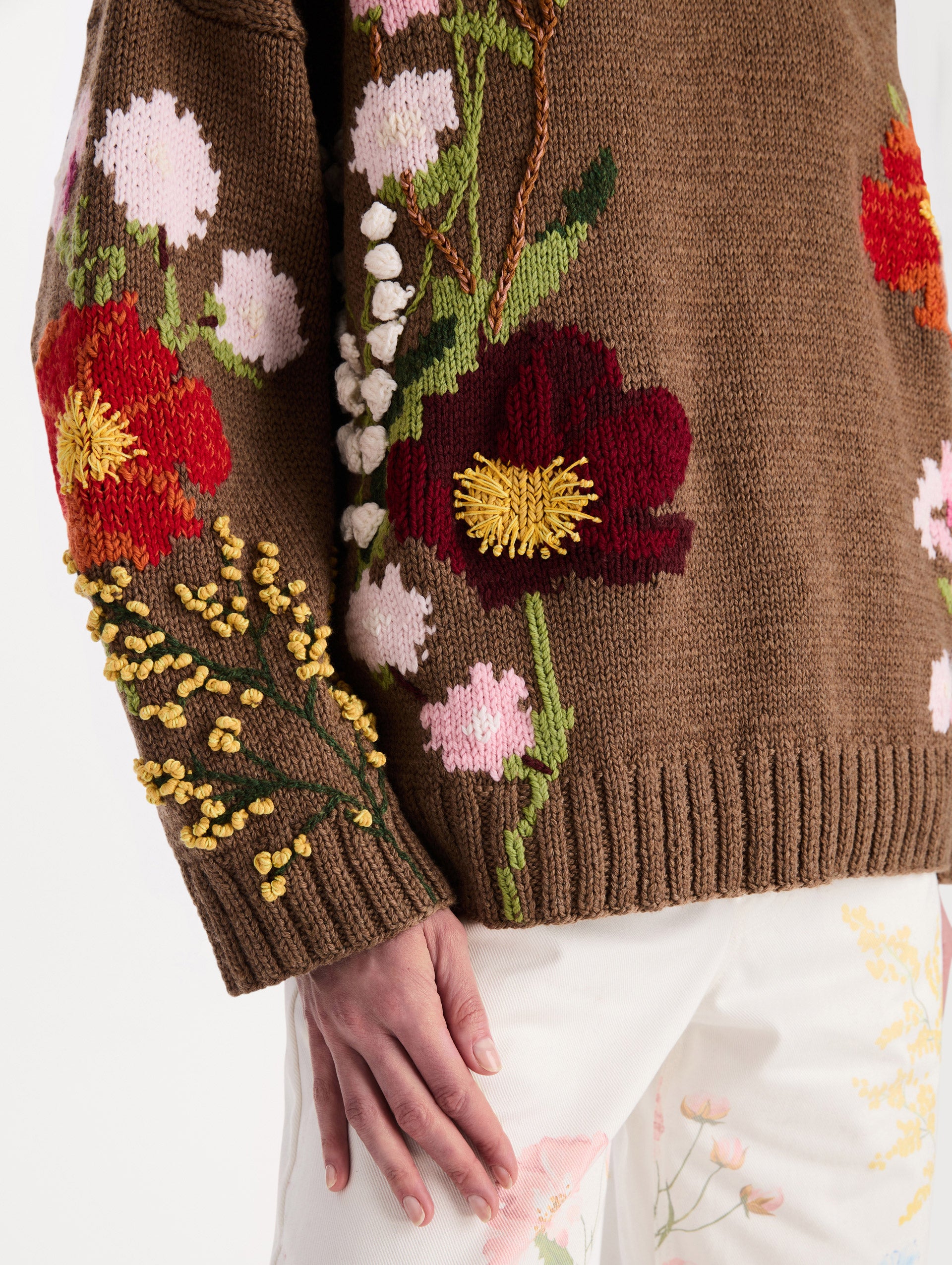 The model is wearing the mixed botanical embroidered oversized pullover with a floral intarsia pattern in the color brown. Zoom view. 