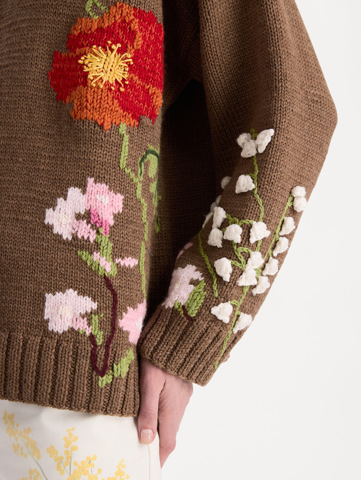 Model wearing a brown wool-cotton oversized pullover with hand-worked floral intarsia embroidery. Zoom View.