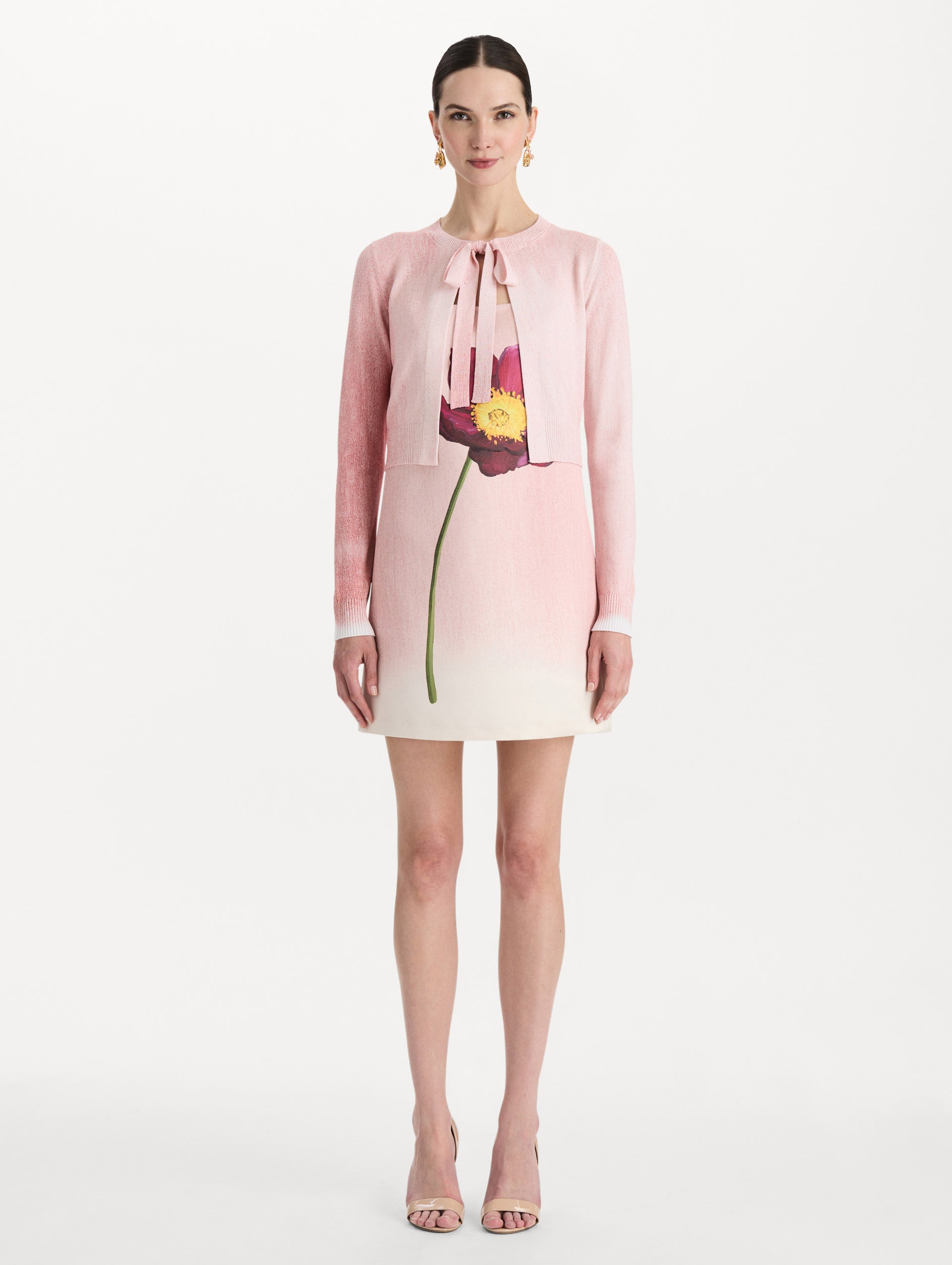 The model is wearing the botanical tie-neck cardigan with a floral print in the color blush. Front view.