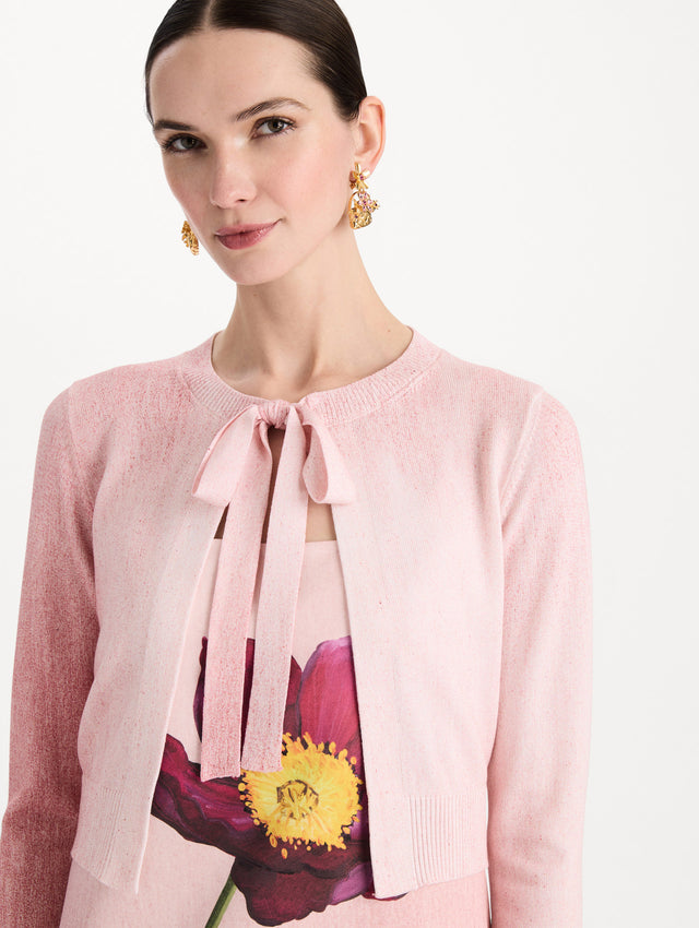 The model is wearing the botanical tie-neck cardigan with a floral print in the color blush. Zoom view.