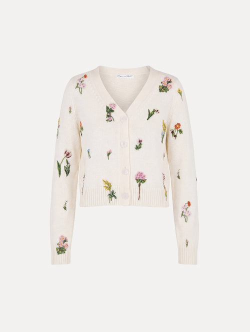 The model is wearing the Beaded Mixed Botanical Embroidered Cardigan with long sleeves in the color ivory. 