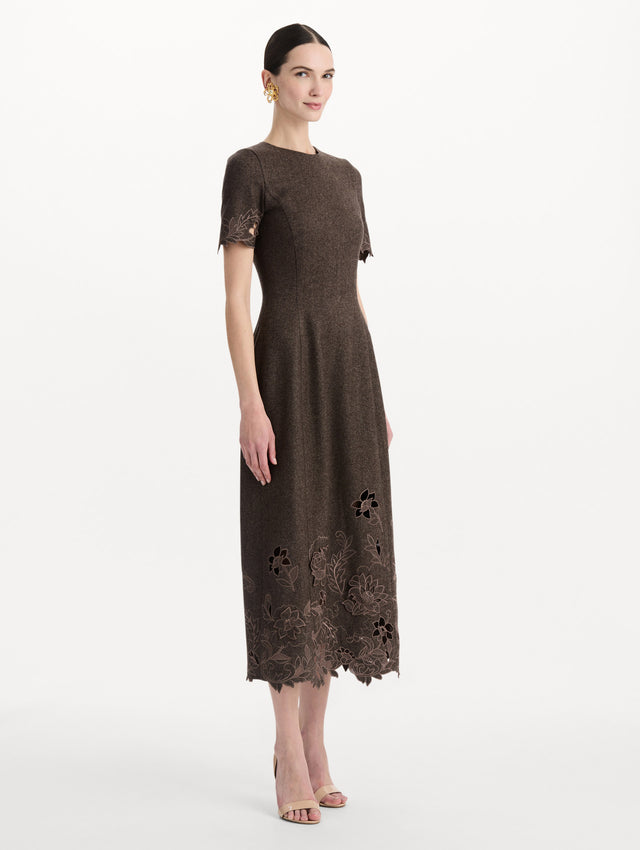 The model is wearing the peony cutout twill herringbone dress with short sleeves in a brown wool-cashmere blend. Side view.