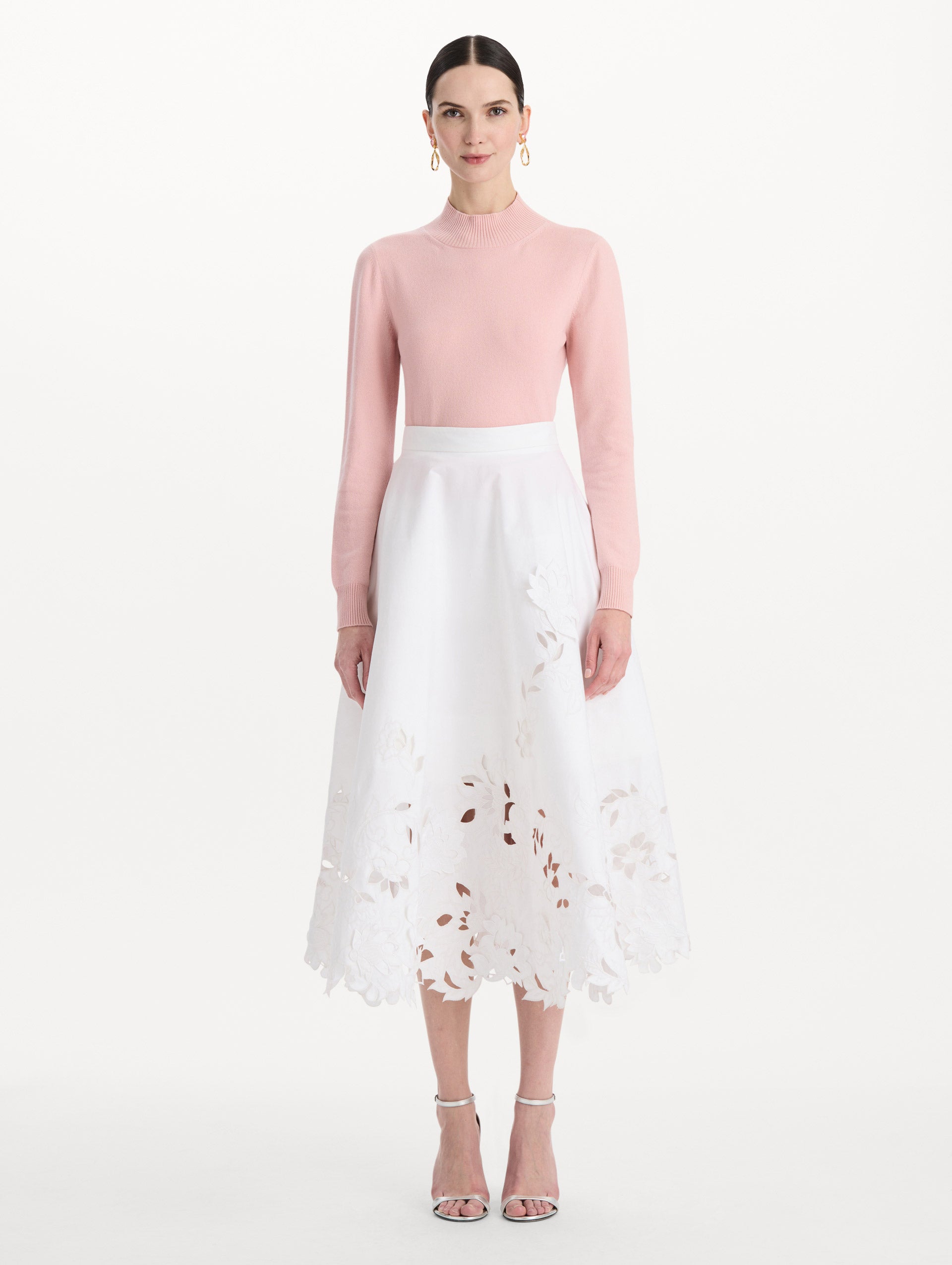 The model is wearing the floral cutout cotton twill skirt with botanical embroidery and a full silhouette in the color white. Front view.