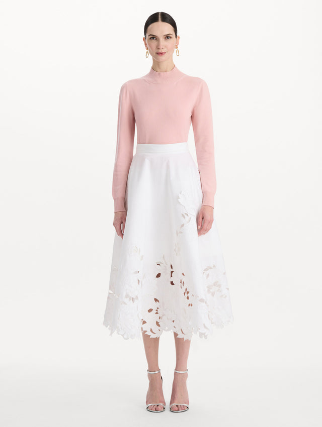 The model is wearing the floral cutout cotton twill skirt with botanical embroidery and a full silhouette in the color white. Front view.