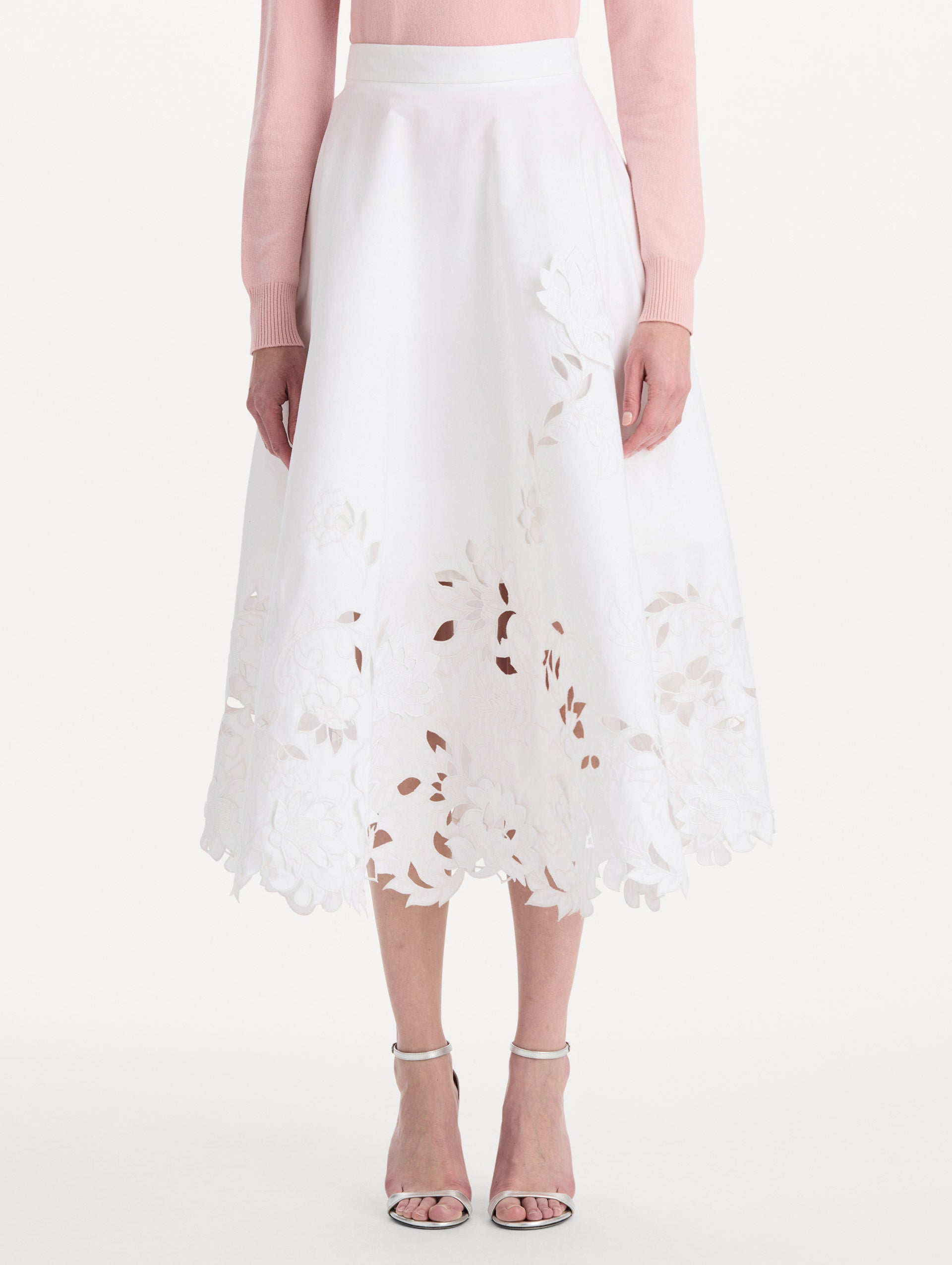 The model is wearing the floral cutout cotton twill skirt with botanical embroidery and a full silhouette in the color white. Front view.