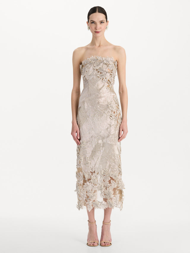 The model is wearing the intarsia leaves cutout embroidered cocktail dress with a strapless silhouette in the color silver. Front view.