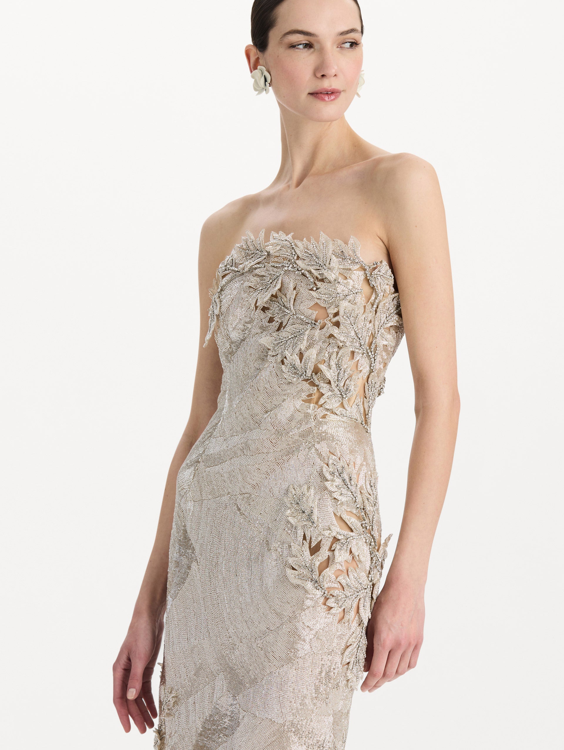 The model is wearing the intarsia leaves cutout embroidered cocktail dress with a strapless silhouette in the color silver. Zoom view.