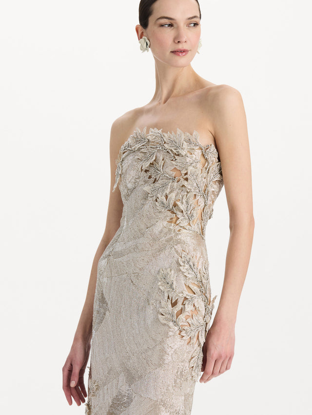 The model is wearing the intarsia leaves cutout embroidered cocktail dress with a strapless silhouette in the color silver. Zoom view.