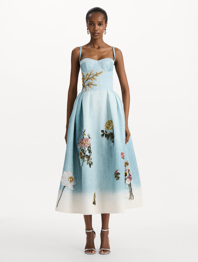 The model is wearing the beaded mixed botanical bustier dress with floral detailing and a sleeveless silhouette in blue multi. Front view. 