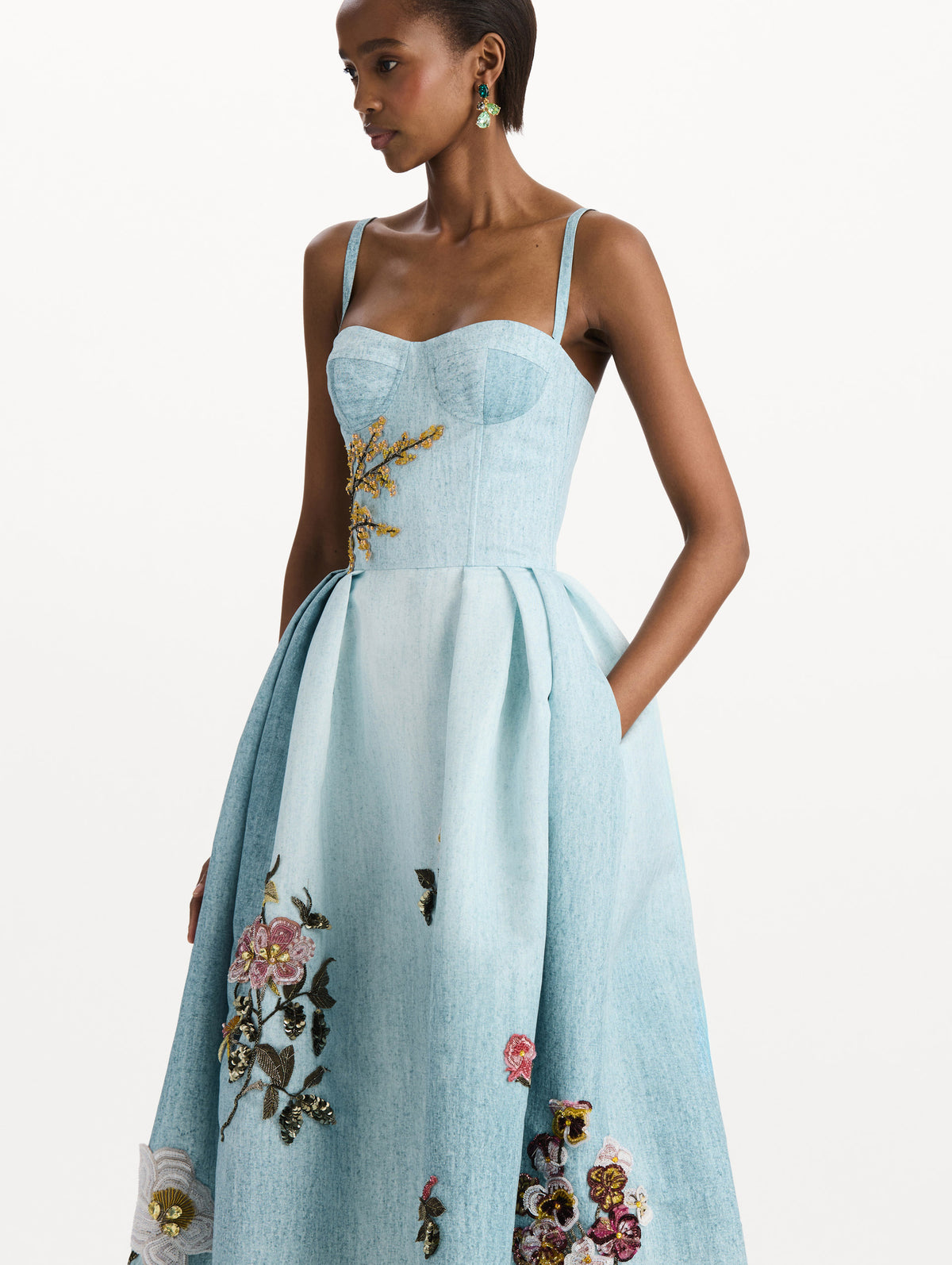 The model is wearing the beaded mixed botanical bustier dress with floral detailing and a sleeveless silhouette in blue multi. Zoom view. 