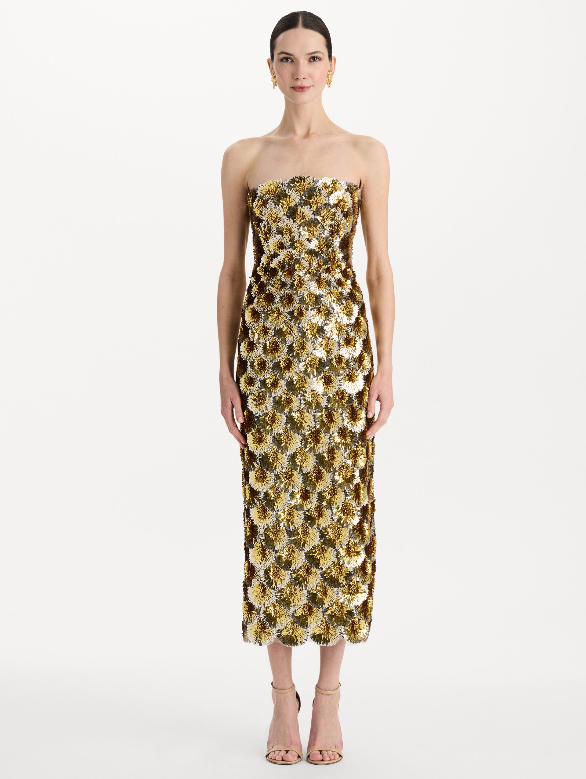 The model is wearing the sequin embroidered scalloped cocktail dress with a strapless, sculptural silhouette in the color yellow. Front view. 