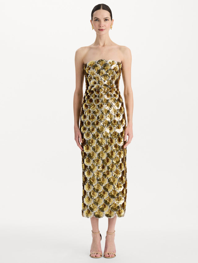 The model is wearing the sequin embroidered scalloped cocktail dress with a strapless, sculptural silhouette in the color yellow. Front view. 