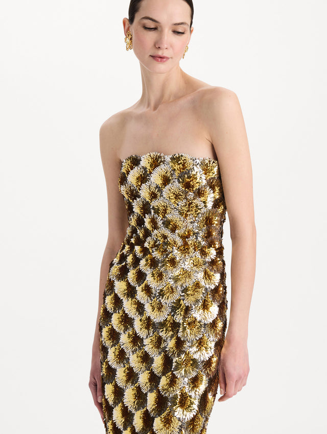 The model is wearing the sequin embroidered scalloped cocktail dress with a strapless, sculptural silhouette in the color yellow. Zoom view. 
