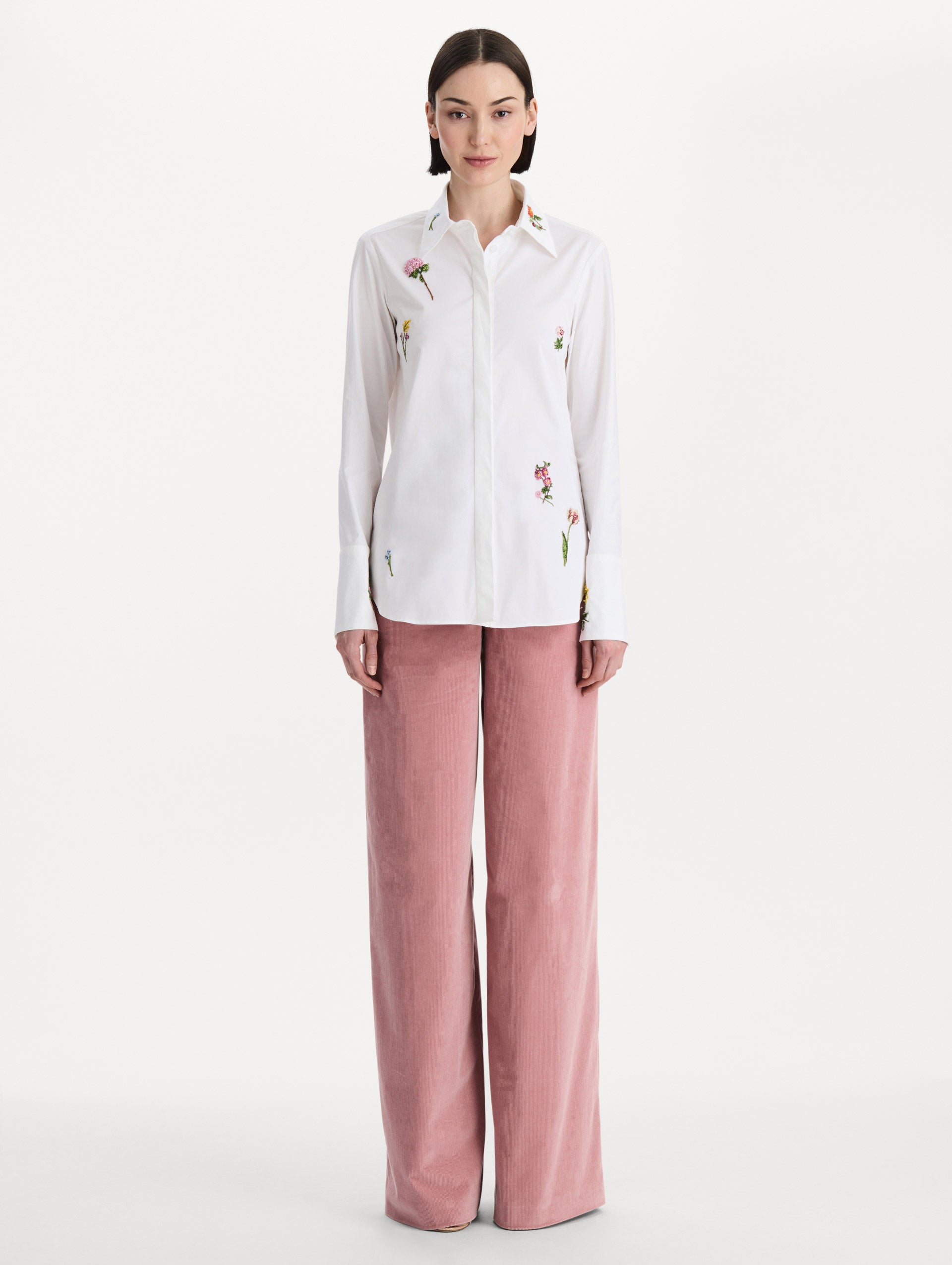 The model is wearing the beaded mixed botanical stretch twill blouse with long sleeves in the color white. Front view. 