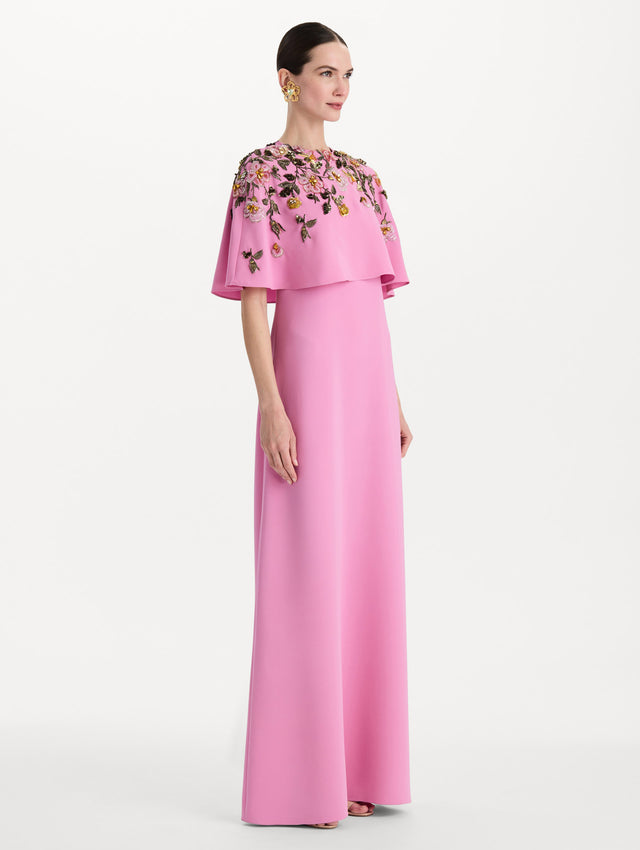 The model is wearing the beaded mixed botanical embroidered caftan in the color pink with floral detailing. Side view. 